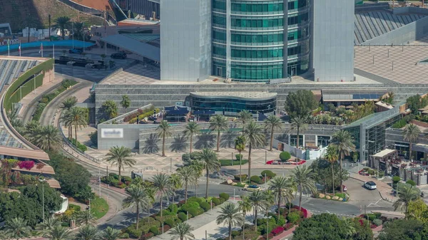 Dubai 'nin finans bölgesindeki kavşak kavşağı yolunun yukarıdan görünüşü. Sokakta trafik vardı, avuçlar gökdelenin girişine yakındı. Dubai, Birleşik Arap Emirlikleri.