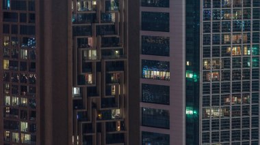 Gecenin ilerleyen saatlerinde gökdelenlerin dış tarafındaki pencereler zaman ayarında parıldıyor ve yanıp sönüyor. Havadan üst görünüm