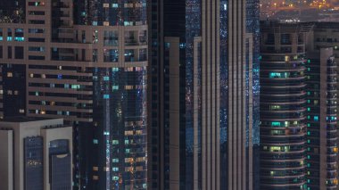 Gecenin ilerleyen saatlerinde gökdelenlerin dış tarafındaki pencereler zaman ayarında parıldıyor ve yanıp sönüyor. Havadan üst görünüm