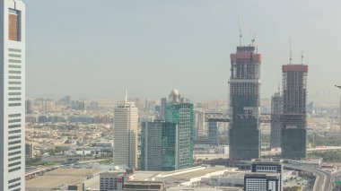 Dubai 'deki Dünya Ticaret Merkezi ile gökdelenlerin hava görüntüsü. Yeni ikiz kulelerin inşaatı. Bur Dubai ve Deira bölgesi akşam saatlerinde arka planda