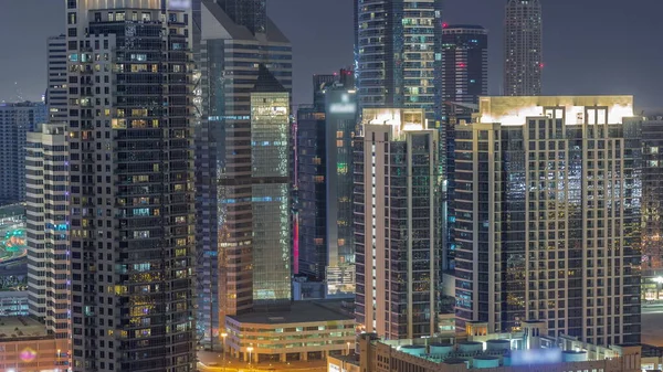 Dubai 'nin iş hanı ofisi ve karşıIıklı kuleler hava gece zaman çizelgesi. Bazı gökdelenlerin çatı manzarası ve kavşaktaki trafik