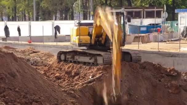 Желтый экскаватор на строительной площадке — стоковое видео