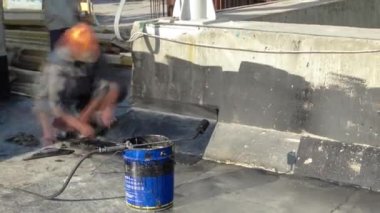 Isıtma ve çatı onarım timelapse sırasında meşale tarafından bitüm atışında alev erime ile çatı ustası çatı yükleme hissettim