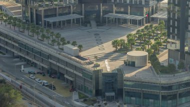 Dubai 'nin finans bölgesindeki iş yerinin girişine yakın avuçları olan çatı bahçesi. Yol ve otoparklı hava manzarası