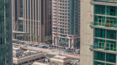 Sheikh Zayed Yolu 'ndaki gökdelenler ve trafik ve Dubai, BAE' deki DIFC zaman çizelgesi. Çatılar ve finans merkezindeki otopark yukarıdan görünüyor..