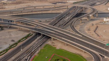 Business Bay Timelapse 'ın kavşağındaki şehir trafiği. Yukarıdan yol kavşağının havadan görünüşü, otomobil trafiği ve birçok arabanın sıkışıklığı. Yeşil çimenli döngü