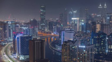 Dubai 'nin modern mimarisine sahip Skyline gece kuleleri aydınlatıyordu. Kanallı hava manzarası ve caddelerde trafik olan inşaat sahası
