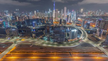 Dubai 'nin panoramik silueti. İş sahası ve şehir merkezi gece zaman çizelgesi yukarıdan. Birçok modern gökdelenin havadan görünüşü. Birleşik Arap Emirlikleri.