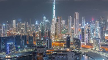 Dubai 'nin panoramik silueti. İş sahası ve şehir merkezi gece zaman çizelgesi yukarıdan. Birçok modern gökdelenin havadan görünüşü. Birleşik Arap Emirlikleri.