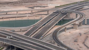 Business Bay Timelapse 'ın kavşağındaki şehir trafiği. Yukarıdan yol kavşağının havadan görünüşü, otomobil trafiği ve birçok arabanın sıkışıklığı. Kanal üzerinde köprü