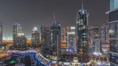Şehirde lüks yat körfezi Dubai marinasında havadan gece saatleri.