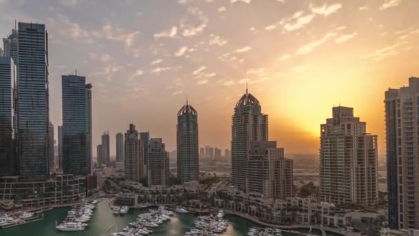 Sunrise over Dubai marina tallest skyscrapers and yachts in harbor aerial morning timelapse. — Vídeo de Stock