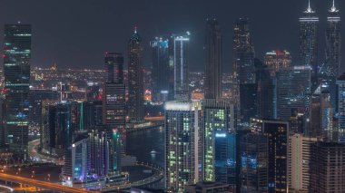 Dubai 'nin modern mimarisine sahip Skyline gece kuleleri aydınlatıyordu. Kanal ve inşaat sahasında köprüleri olan hava manzarası