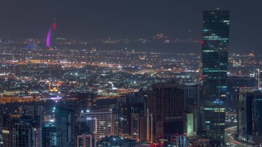 Dubai 'nin modern mimarisine sahip Skyline, arka plan gece zaman çizelgesinde evleri ve villaları olan kuleleri aydınlattı. Kanal ve şantiyeli hava manzarası