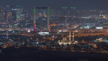 Modern gökdelenleri olan Dubai şehrinin silueti ve Deira ve Zabeel ilçelerindeki aydınlık camii Birleşik Arap Emirlikleri Business Bay 'den gece hava durumu zaman çizelgesi