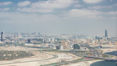 Deira Creek ve Zabeel bölgesinde modern gökdelenleri olan Dubai şehrinin panoramik silueti ve Business Bay 'den gelen büyük otoyol kavşağı zaman dilimi. Bulutlu gökyüzü, Birleşik Arap Emirlikleri