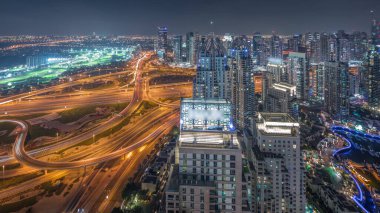 Dubai marinası ve JLT, Sheikh Zayed Yolu 'ndaki gökdelenleri büyük bir kavşak noktası olan gece zaman çizelgesiyle aydınlattı. Yukarıdan konut ve ofis binaları.
