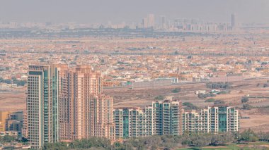 Dubai marinasından yeşilliklerin hava görüntüsü. Yukarıdan arka planda birçok villa evi olan kuleler ve gökdelenler. Önünde golf sahası var.