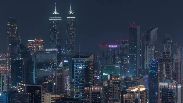 天际线与现代迪拜商业区的建筑交相辉映 塔顶灯火通明 有建筑工地的空中景观 — 图库照片