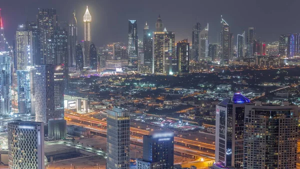 迪拜金融区和商业区的摩天大楼夜间经过 许多照明塔和别墅的全景景观 — 图库照片