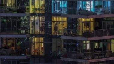 Çok katlı binaların pencerelerinde düz gece panoramasında çok renkli ışık var..