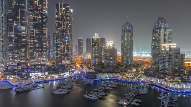 Dubai Marina luxury tourist district with skyscrapers and towers around canal aerial night timelapse — 图库视频影像