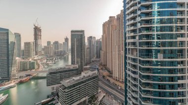 Panorama, JBR ve Dubai Marina gökdelenlerinin gökdelenlerinin gökdelenlerini gösteriyor. Kanal suyunda yüzen yatlar. Arka planda JLT bölgesi