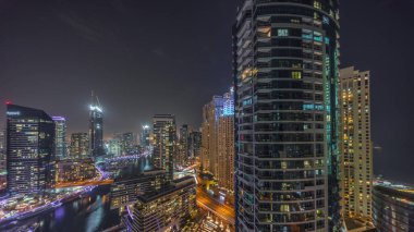 JBR kulelerine ve Dubai marinasına açılan hava panoramik manzara kanalın etrafındaki gökdelenleri gece saatlerinde yüzen yatlarla aydınlattı. Yat kulübünde beyaz tekneler var.