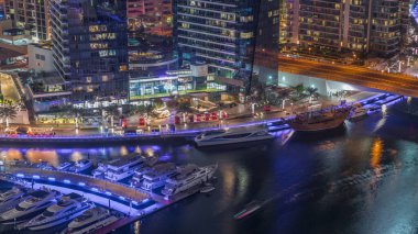 Dubai marinası rıhtımda gece vakti hava kanalı boyunca gezinti yaptı. Dubai 'de yüzen yatları ve tekneleri olan modern yerleşim yerleri.