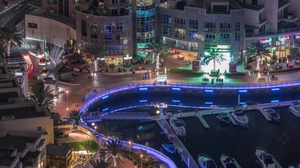 Dubai Marina rıhtımında, avuçlarında avuçlar, gece uçuşu zamanlaması, Dubai, BAE. Birçok restoran ve yüzen yatlar