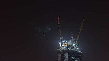 Gökdelen yapım aşamasında vinçler ve demir çerçeveli gece zaman ayarlı. Yeni çok katlı kule inşaatı
