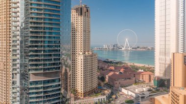 JBR bölgesinin panoramik manzarası ve güneş doğarken uzun gölgelerle birlikte sisli gökdelenler ve Ferris Wheel 'in meşhur sabah saatleri.