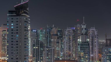 Dubai Marina Skyline 'ın arka planında JLT gökdelenleri var. Camdan yüzeyi ve metro istasyonu manzaralı aydınlık kuleler.