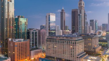 Dubai Uluslararası Finans Bölgesi gece gündüz geçiş zamanı. Gün doğmadan önce iş yerinin gökyüzü manzarası. Şehir merkezine yakın otellerle aydınlatılmış gökdelenler.