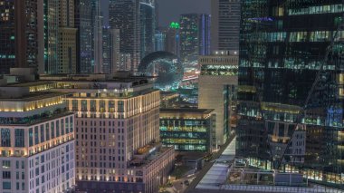 Dubai Uluslararası Finans Bölgesi Gece Zaman Çizelgesi. İş yeri kulelerinin havadan görüntüsü. Oteller ve müzelerle aydınlatılmış gökdelenler.