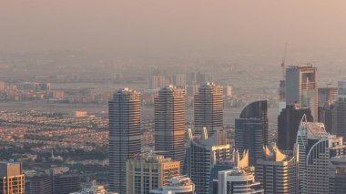 Jumeirah Lakes Kuleleri bölgesinde Şeyh Zayed Yolu boyunca birçok gökdelen bulunuyor. Akşamları JLT 'de konut binaları ve villalar turuncu ışık altında.