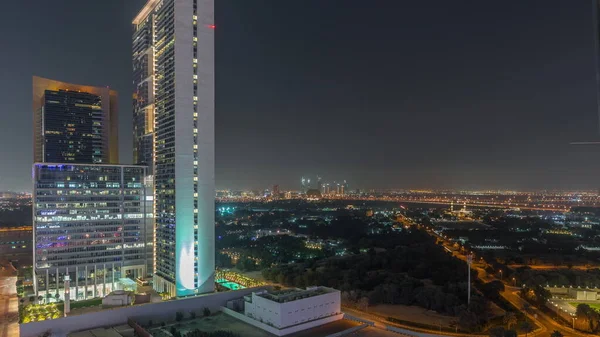 在阿联酋迪拜 Zabeel区的花园 背景空中经过一幢写字楼 有照明别墅和宾馆的街道上的交通 — 图库照片