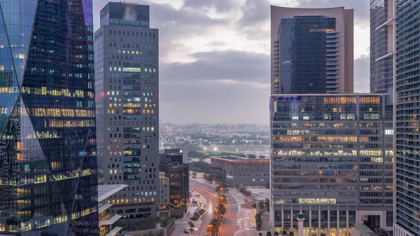 Dubai Uluslararası Finans Bölgesi gece gündüz geçiş zamanı. Gün doğmadan önce iş yerinin gökyüzü manzarası. Arka planda karayolu trafiği ve Deira ilçesi ile aydınlanan gökdelenler