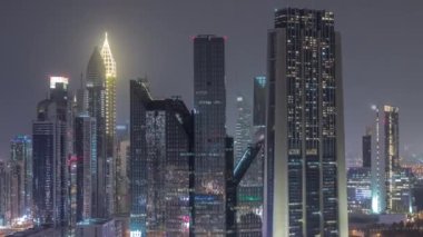 Dubai Finansal Merkezi 'nin gece saatlerinde aydınlatılmış gökdelenleri ile yakın görüntüsü.