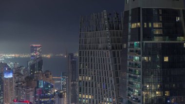 Yukarıdan JBR ve Dubai Marina gökdelenleri ve lüks binaların hava görüntüsü. Parlak pencereli aydınlık kuleler