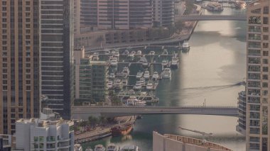 Dubai Marina kıyı şeridi boyunca gökdelenlerle çevrili yapay bir kanalı gösteriyor. Limanda yüzen yatlar ve tekneler. Dubai, BAE