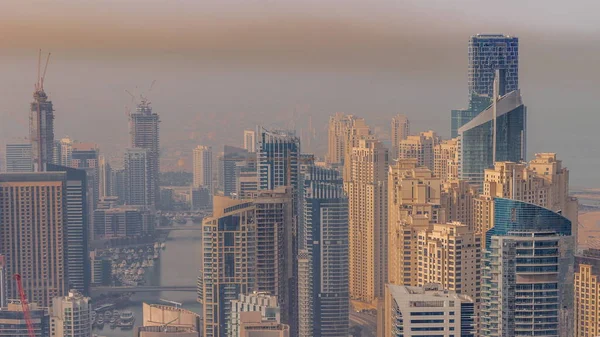 Dubai Marina ve JBR 'nin Skyline panoramik görüntüsü kıyı şeridi boyunca gökdelenlerle çevrili yapay bir kanal gösteriyor. Sıcak sabah ışığında yüzen yatlar ve tekneler. Dubai, BAE