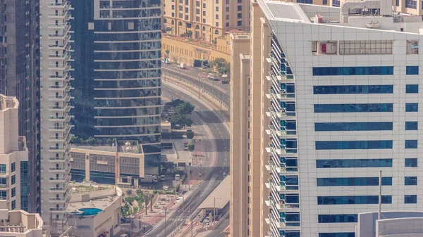 Yukarıdan JBR ve Dubai Marina gökdelenlerinin ve lüks binaların hava manzarası. Kavisli yolda trafik olan modern kuleler