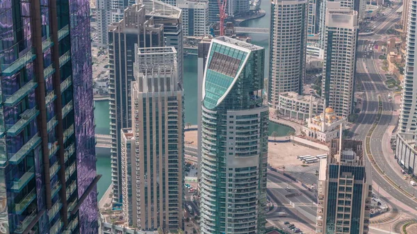 Dubai Marina 'nın Skyline manzarası kıyı şeridi boyunca gökdelenlerle çevrili yapay bir kanal gösteriyor. Rıhtım yakınında yüzen yatlar ve cami. Dubai, BAE