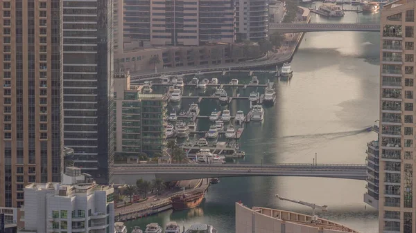Dubai Marina kıyı şeridi boyunca gökdelenlerle çevrili yapay bir kanalı gösteriyor. Limanda yüzen yatlar ve tekneler. Dubai, BAE