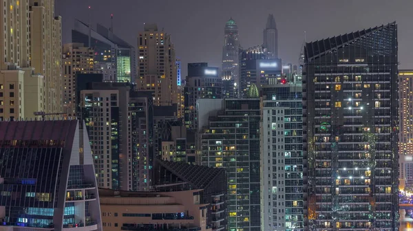Dubai Marina 'daki modern gökdelenler, birçok aydınlık pencereye yakın gece zaman aralığı. Yukarıdan modern kuleler