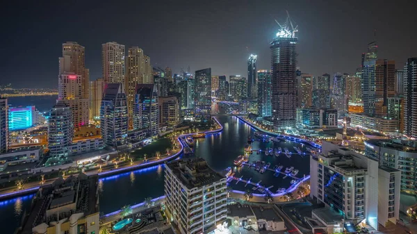 Dubai Marina 'da limana park etmiş birkaç tekne ve yatı var. Kanal havası çevresindeki gökdelenleri aydınlatıyorlar. JBR bölgesi ve şantiye panoramik manzarasının kuleleri