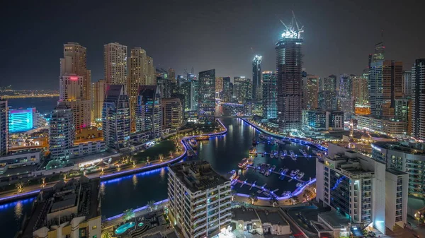 迪拜码头有几艘船和游艇停靠在港口 并照亮了运河空中夜间时间周围的摩天大楼 Jbr区塔楼及建筑工地全景 — 图库照片