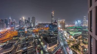 Fütürist Dubai Şehir Merkezi ve finans bölgesi gökyüzü gece kuşağı panoraması. Birçok aydınlık kule ve gökdelenler caddelerde trafik var.