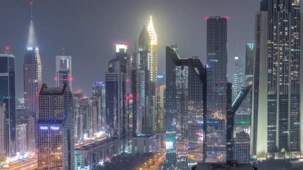 Panorama del distrito del Centro Financiero de Dubai con rascacielos altos iluminados toda la noche timelapse. — Vídeos de Stock